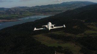 WAAF02_C040_0117KA - 4K stock footage aerial video reveal a Learjet C-21 while flying over hills on the coast in Northern California