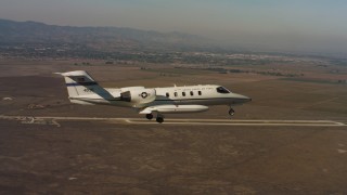 WAAF02_C065_0117R0 - 4K stock footage aerial video of a Learjet C-21 flying near Travis Air Force Base, California