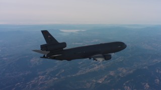 WAAF03_C012_0118D4 - 4K stock footage aerial video of revealing a McDonnell Douglas KC-10 flying over hills in Northern California
