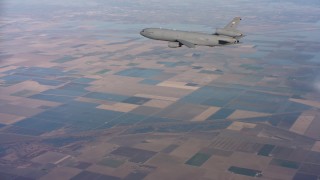 WAAF03_C015_01181L - 4K stock footage aerial video of flying around the tail of a McDonnell Douglas KC-10 over farmland in Northern California