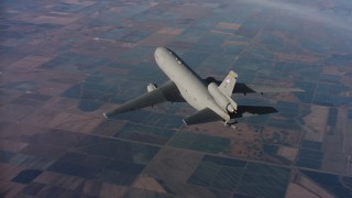 WAAF03_C017_01180A - 4K stock footage aerial video of flying around the tail of a McDonnell Douglas KC-10 over farms in Northern California