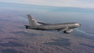 WAAF04_C008_0118BS - 4K stock footage aerial video of a Boeing KC-135 flying over hills toward a bay in Northern California