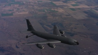 WAAF04_C022_0118CS - 4K stock footage aerial video of a Boeing KC-135 flying over farms with lowered fuel boom in Northern California