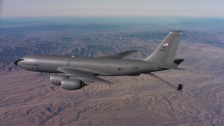 WAAF04_C025_0118FV - 4K stock footage aerial video pan to reveal a Boeing KC-135 flying over mountains in Northern California