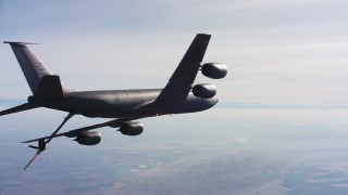 WAAF04_C032_0118WT - 4K stock footage aerial video of a Boeing KC-135 flying over farmland and out of frame, Northern California