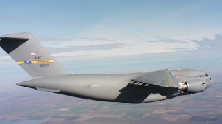 WAAF05_C010_0118DP - 4K stock footage aerial video of a Boeing C-17 in flight over farmland, Northern California