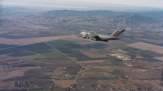 WAAF05_C026_0118U2 - 4K stock footage aerial video of a Boeing C-17 over farmland with cargo door open in Northern California