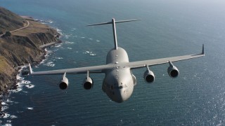WAAF05_C037_0118FD - 4K stock footage aerial video of a Boeing C-17 flying along the coast in Northern California