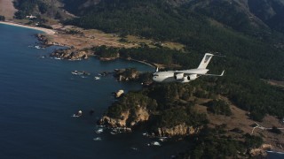 WAAF05_C046_011850 - 4K stock footage aerial video of a Boeing C-17 flying away from the coast of Northern California