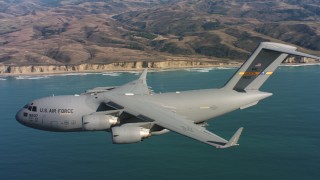 WAAF05_C059_011850 - 4K stock footage aerial video of a Boeing C-17 flying over ocean as cargo doors close in Northern California 