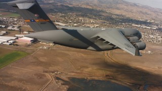 WAAF05_C074_01187N - 4K stock footage aerial video of a Boeing C-17 in flight near neighborhoods in Northern California