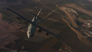 WAAF06_C026_0119G8 - 4K stock footage aerial video of flying around the front end of a Lockheed Martin C-130J at sunset, Northern California