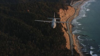 WAAF06_C072_01194X - 4K stock footage aerial video of a Lockheed Martin C-130J following the coast at sunset in Northern California
