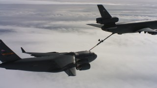 WAAF07_C051_0119AJ - 4K stock footage aerial video of a McDonnell Douglas KC-10 fueling a Boeing C-17 above clouds in Northern California
