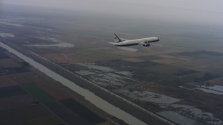 WAAF08_C015_01193S - 4K stock footage aerial video of a Boeing C-32 in flight over a river and farms in Northern California