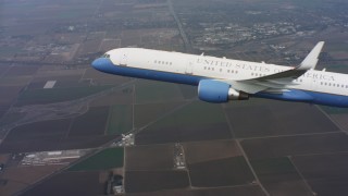 WAAF08_C018_0119DD - 4K stock footage aerial video reveal a Boeing C-32 flying over farmland in Northern California