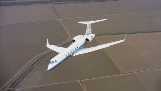 WAAF08_C055_0120W9 - 4K stock footage aerial video of a Gulfstream C-37A flying over canals and farms in Northern California