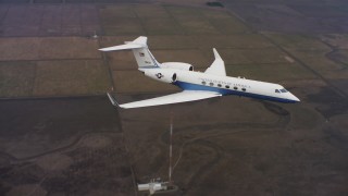 WAAF08_C061_012061 - 4K stock footage aerial video of flying around the nose of a Gulfstream C-37A in flight over farms in Northern California